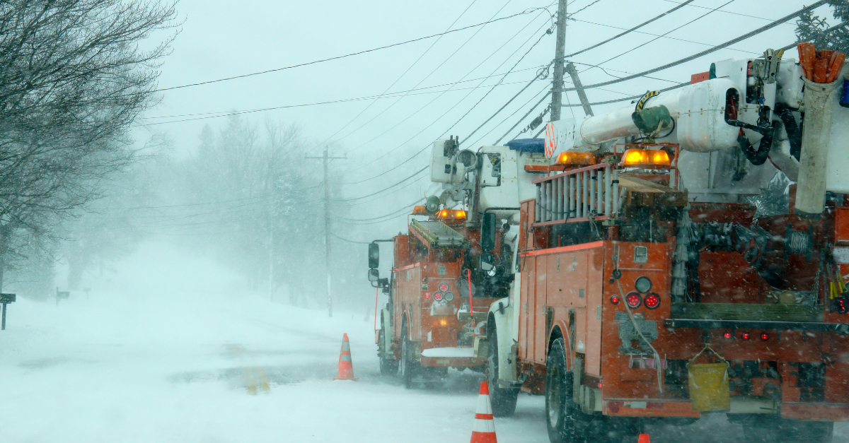 Snowplows and electrical workers during a winter storm snowstorm