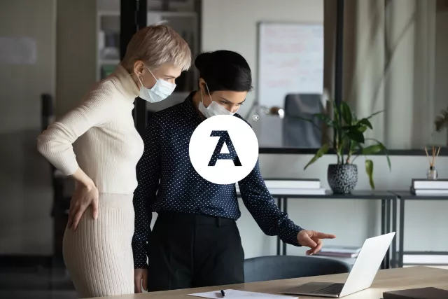 Two people working with masks on