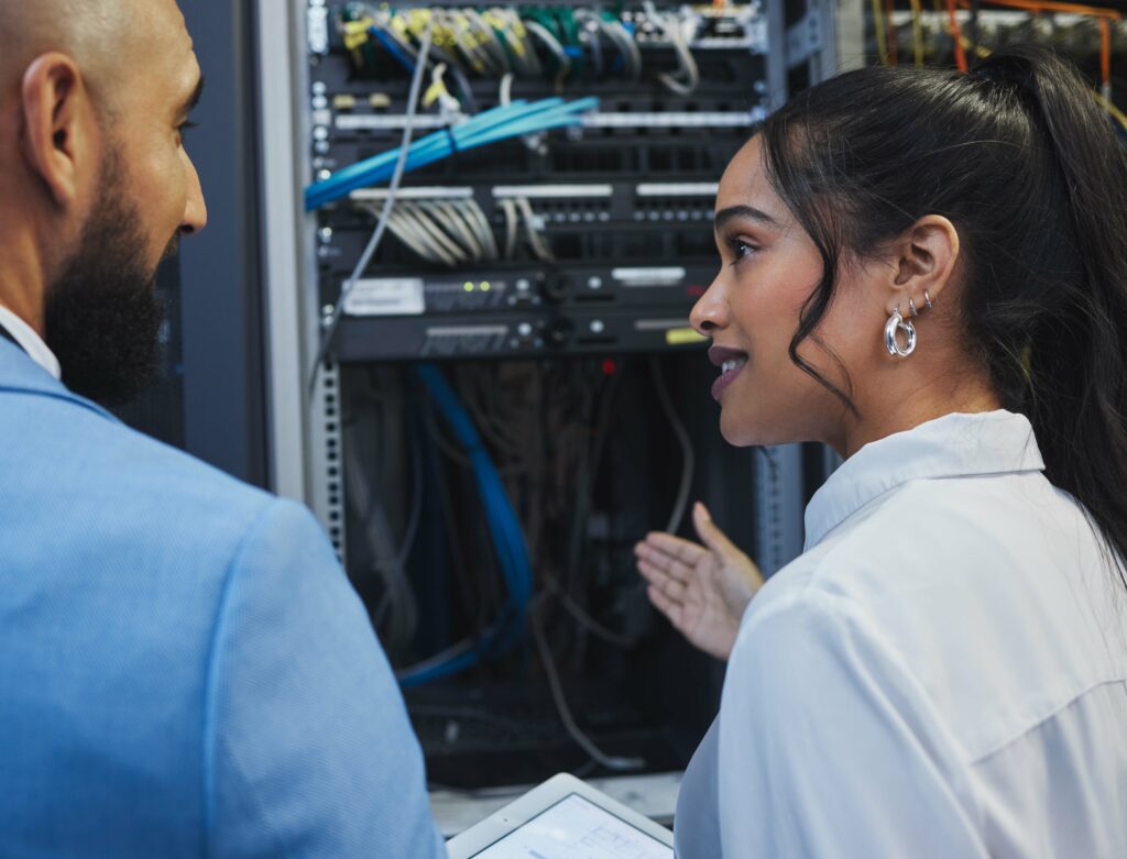 Two people standing near servers
