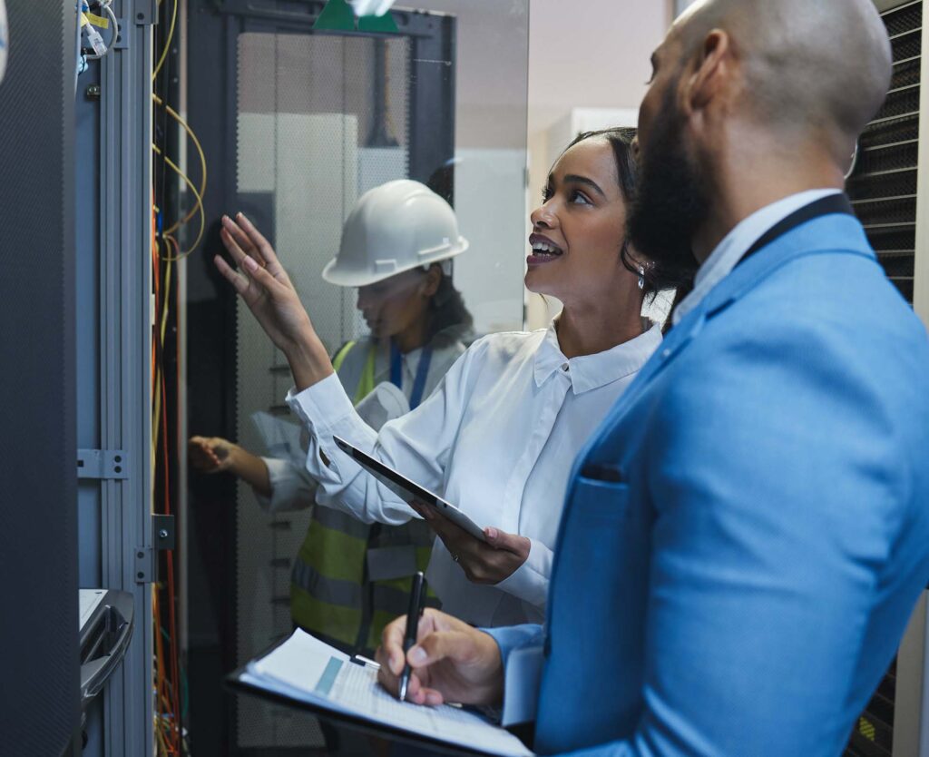 Shot of two workers inspecting the electronic equipment in a server room together at work.