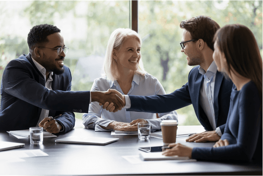 Group of people around a table and people shaking hands