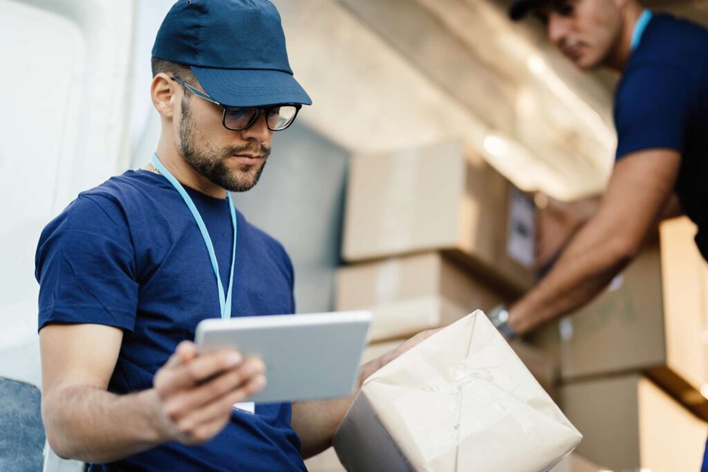 man in a warehouse checks boxes