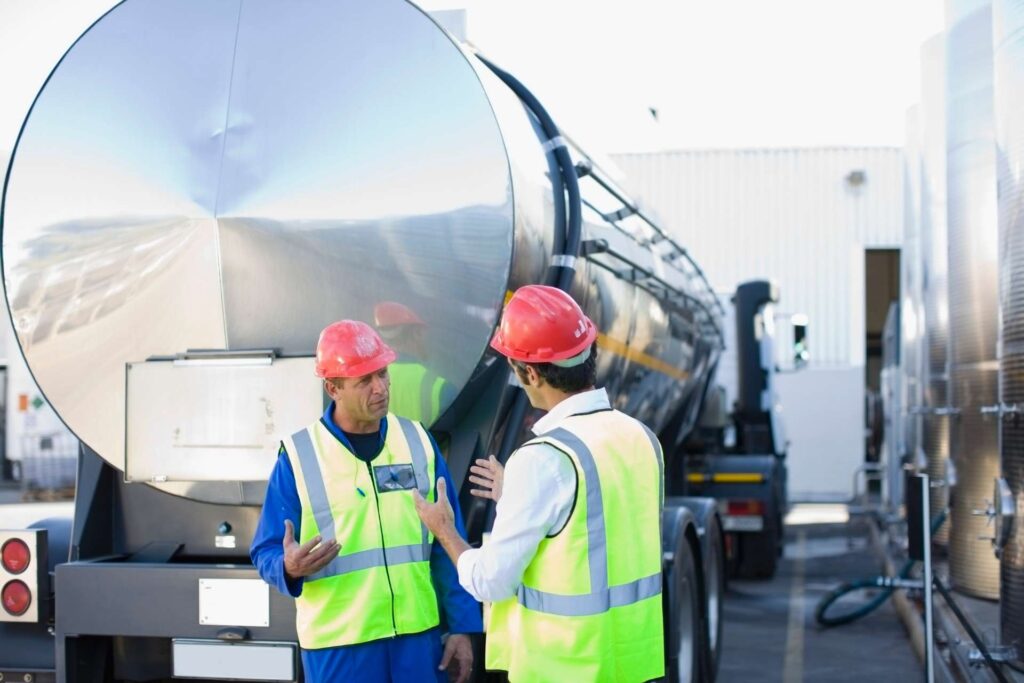 workers talking in front of a tanker truck