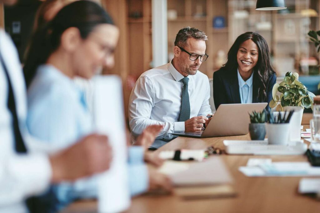 People at a conference table smiling and working