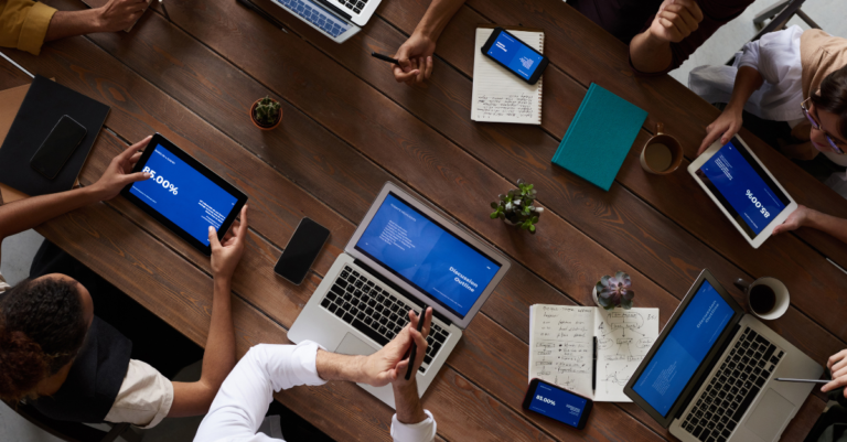 Meeting around a table with tablets and laptops