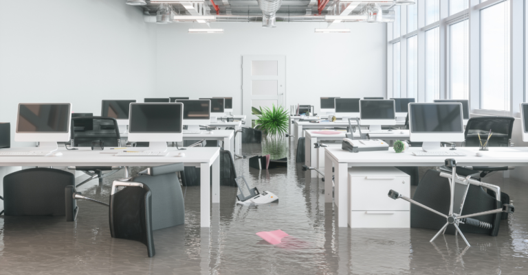 Flooded office building with water damage to workstations and equipment